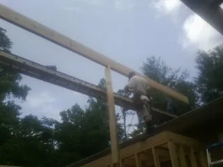 Carpenter setting a ridge beam over a new addition frame — Ice Dam Removal by Roofing Brothers in Pendergrass