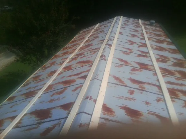 Rusted metal roof panels with new wood purlins before replacement — Storm Damage Roof Repair in Pendergrass by Roofing Brothers