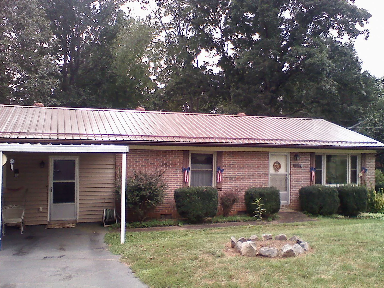 Bronze metal roof and carport on a brick ranch home — Roof Repair work by our crew in Pendergrass